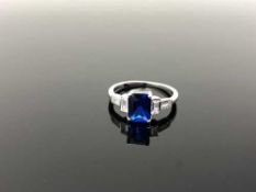 A Sterling silver Art Deco style emerald cut ring set with a blue stone, size N.