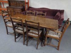 An oak refectory dining table together with six ladder backed chairs
