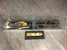 Three model ships, two under glass domes, longest 61cm.