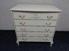 A cream and gilt five drawer chest