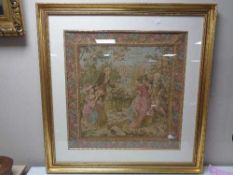 A gilt framed tapestry depicting figures in a garden
