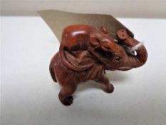 A carved fruitwood netsuke in the form of a rat riding an elephant