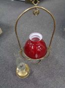 A brass Art Nouveau hanging oil lamp with glass shade and chimney