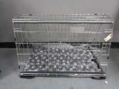 A folding black metal dog cage, height 52 cm, width 82 cm, depth 50 cm.