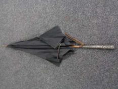 An antique parasol with silver handle
