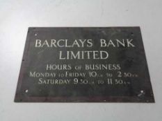 A brass Barclays bank limited business hours plaque