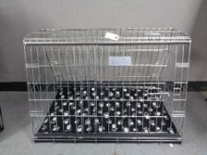 A folding black metal dog cage, height 67 cm, width 86 cm, depth 56 cm.