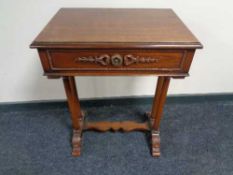 A reproduction mahogany work table with under stretcher and column supports