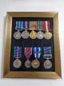 Nine reproduction military medals on ribbons in frame