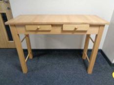 A pine effect side table fitted with two drawers