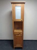 A double door narrow storage cupboard fitted with a drawer