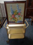 A tapestry fire screen on brass feet together with a gilt three tier trolley
