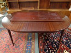 A twentieth century circular mahogany dining table with three leaves