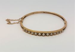 An antique gold and pearl hinged bangle CONDITION REPORT: 8.