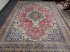 A machine made Persian design woolen carpet on pink ground, 383cm by 281cm.