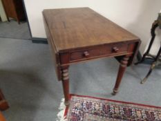 A Victorian mahogany flap sided table fitted with two drawers