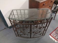 A wrought metal glass topped wine cabinet