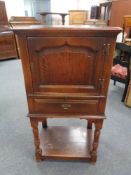 An oak Georgian style cupboard fitted a drawer beneath on raised legs