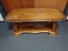 A heavy two tier coffee table fitted with a drawer in oak finish