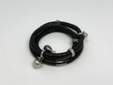 A Story Bangle by Kranz & Ziegler with six silver charms including a black pearl