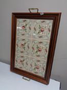 A brass handled tiled serving tray