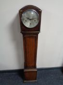 An oak cased granddaughter clock with silvered dial