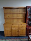 A pine dresser fitted with doors and cupboard beneath