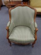 A beech framed salon armchair in green striped fabric