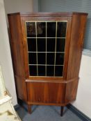 A mid century Danish corner cabinet with leaded glass door