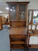 An oak Arts and Crafts bureau bookcase with leaded glass doors