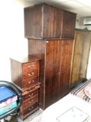 A stained pine double door wardrobe together with top box and pair of three drawer bedside chests