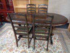 An oval oak refectory dining table fitted with internal leaf together with a set of four ladder
