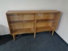 A mid century teak four drawer sliding glass door bookcase