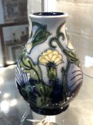 A Moorcroft vase, yellow flowers on blue ground, height 13.5 cm, signed to base.