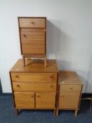 A mid century teak linen cabinet together with pair of cabinets fitted with a drawer