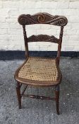 Antique carved back Victorian chair with caned seat.