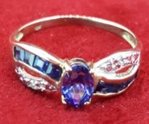 Yellow Metal Oval Tanzanite & Diamond Crossover Style Ring