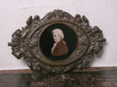 Ovaler Rahmen (im Stil des Historismus), wohl aus Bakelit, aufwendig gearbeitet, m. Foto von Mozart,