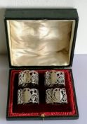 A George V cased set of four silver napkin rings with pierced decoration, numbered, hallmarked and