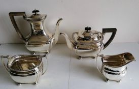 An Edwardian four-piece silver tea and coffee service with fruitwood harp handles, leaf scroll