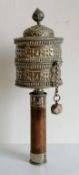 A Tibetan silver prayer wheel, with a bamboo handle, 26 cm long