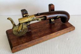 A 19th century eprouvette or gunpowder tester, the mahogany pistol grip with brass barrel, touch