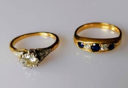 An early 20th century diamond solitaire ring in a claw setting with diamond decoration to