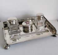 A George V silver ink stand with twin squared-based ink bottles, pierced gallery, enamelled