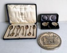 A George V cased set of six silver coffee spoons and tongs with rococo decoration to terminals by