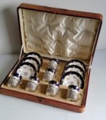 A cased set of six Edwardian Coalport floral and gilt-edged coffee cans and saucer with pierced
