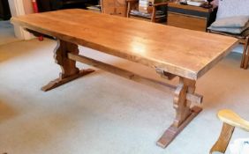A hardwood Arts & Crafts-style refectory dining table with carved trestle supports, 75 x 200 x 79 cm