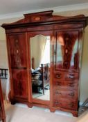 An Edwardian bedroom suite comprising: a treble wardrobe with carved pediment, interior fitted for