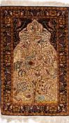 A Kashmir 'silky' rug:, the ivory mihrab with a design of birds amidst a flowering tree,