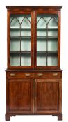 A 19th Century mahogany bookcase:, the upper part with a moulded dentil cornice,